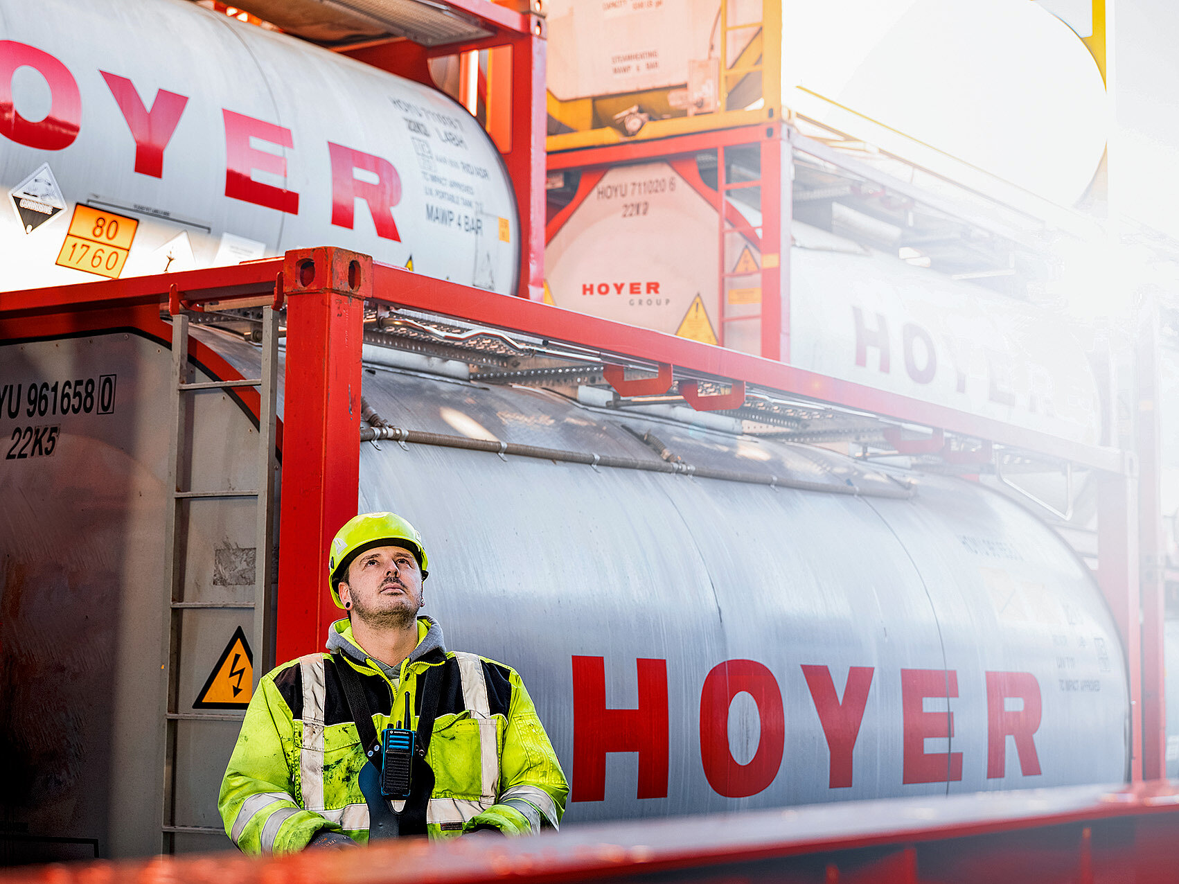 Chemielogistik HOYER Mitarbeiter steht hinter HOYER Container und bedient einen Kran